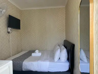a hotel room with a bed with pillows and a mirror at Prime Executive Accommodation in Cape Town