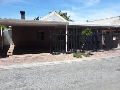 a house with a fence on the side of the street at Tolbos Backpackers in Worcester