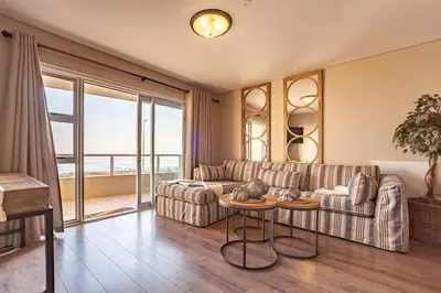 a living room with a couch and a table at Beachfront Luxury Living- A106 Seaspray, Blouberg in Bloubergstrand