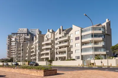 a large apartment building in front of a street at Beachfront Luxury Living- A106 Seaspray, Blouberg in Bloubergstrand