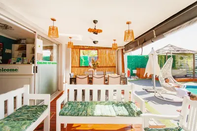 a living room with white chairs and a pool at Caline VIP Luxury Jacuzzi &, Swimming Pool MEWS in Cape Town