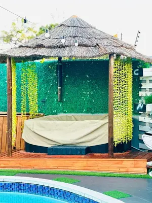 a gazebo with a green wall next to a pool at Caline VIP Luxury Jacuzzi &, Swimming Pool MEWS in Cape Town
