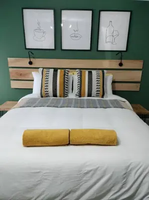 a large bed with a yellow blanket on it at Champers in Cape Town