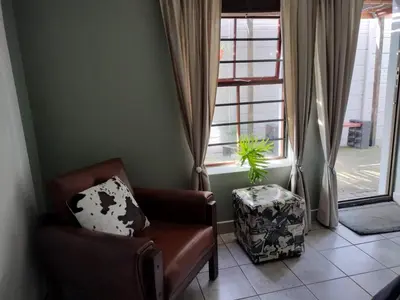 a living room with a chair and a window at Champers in Cape Town