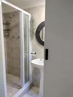 a bathroom with a shower and a sink at Champers in Cape Town