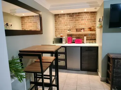 a kitchen with a table and two stools at Champers in Cape Town