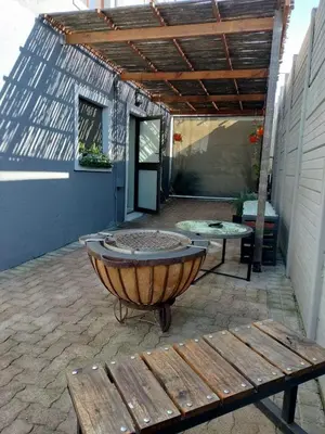 a patio with a large tub and a bench at Champers in Cape Town