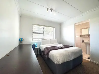 a bedroom with a bed and a sink in it at Spacious Double Room for Two with Pool, Braai, Gas Stove, Complete Kitchen, Fast WiFi and Private Bathroom in Cape Town