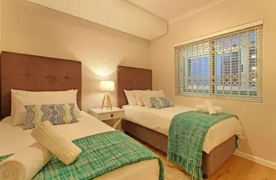 a bedroom with two beds and a window at Private Blouberg Beachfront Getaway in Cape Town