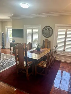 a dining room table with chairs and a clock on the wall at French Manor 2 Stellenbosch in Stellenbosch