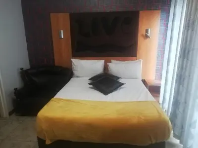 a bed with a black pillow on top of it at Parow city -Star Legend Lodge in Cape Town