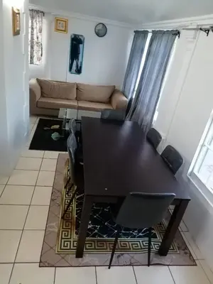 a living room with a table and chairs and a couch at 37 Grant prix lodge in Cape Town