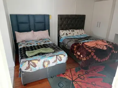 two beds sitting next to each other in a room at 37 The trout Lodge in Cape Town