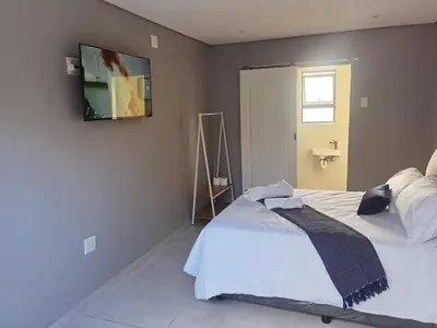 a bedroom with a bed with a tv on the wall at 160 On Townsend Guesthouse in Cape Town