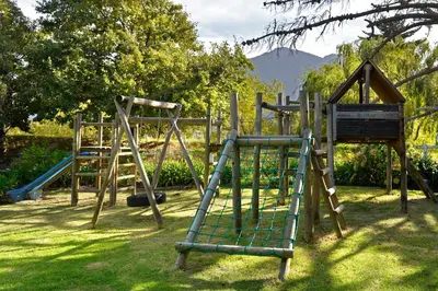 an old playground with a slide and a swing set at Bo La Motte Farm Cottages in Franschhoek