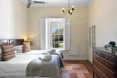 a bedroom with two beds and a window at Bo La Motte Farm Cottages in Franschhoek