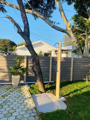 a tree in a yard next to a fence at Flaming Place in Cape Town
