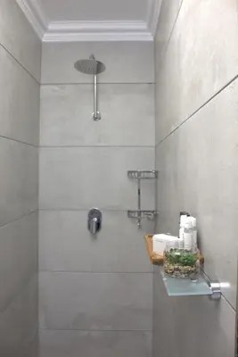 a bathroom with a shower with a glass door at Charming Modern Bedsitter in Cape Town