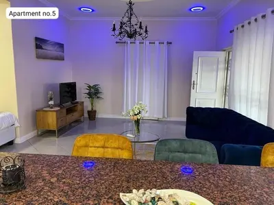 a living room with purple walls and a table and chairs at Serena Inn Apartment no5 Self Catering in Cape Town