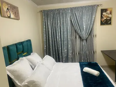 a bedroom with a bed with white pillows and a window at Sabbath Lodge VIP in Cape Town