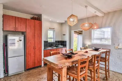 a kitchen with a wooden table and a refrigerator at Mountain View in Bettyʼs Bay