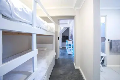 a room with two bunk beds and a hallway at Beautiful family beach cottage! in Pringle Bay