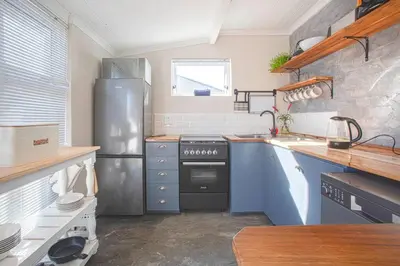 a kitchen with a refrigerator and a stove at Beautiful family beach cottage! in Pringle Bay