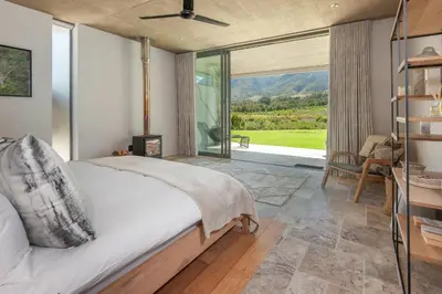 a bedroom with a bed and a large window at Villetta in Mosselrivier