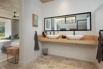 two sinks in a bathroom with a bedroom at Villetta in Mosselrivier