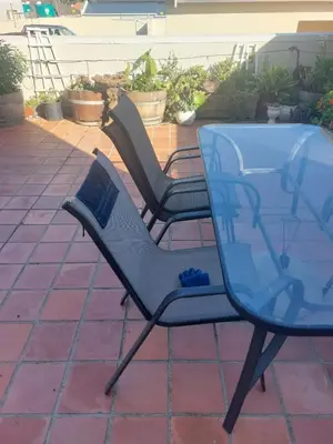 two chairs and a glass table on a patio at Self-Catering Apartment near beach in Strand
