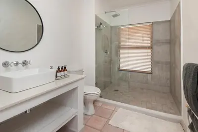 a bathroom with a shower and a sink and a toilet at Casa La Vita in Hermanus