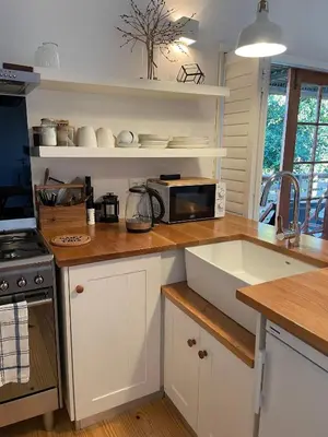 a kitchen with a counter with a microwave and a sink at Sunset Beach Studio Apartment in Cape Town