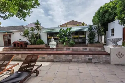 a patio with two benches and a building at Rondebosch in Cape Town