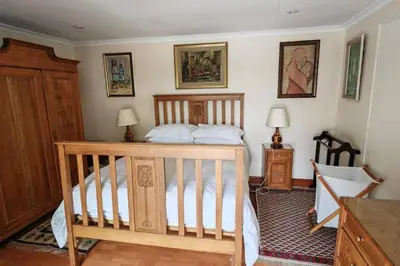 a bedroom with a wooden bed with two tables and two lamps at Rondebosch in Cape Town