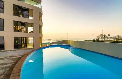a swimming pool in front of a building at Ocean View 1004 Luxury Backup Power in Strand