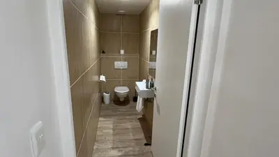 a small bathroom with a toilet and a sink at Ocean View 1004 Luxury Backup Power in Strand