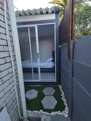 a small backyard with a bed in a window at Cozy Business overnighter in Bellville