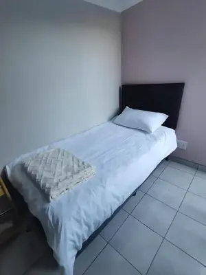a bedroom with a white bed with a black headboard at Cozy Business overnighter in Bellville
