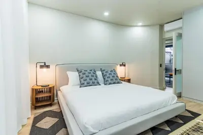 a bedroom with a large white bed with two pillows at Modern Central 1 BR Apartment in Stellenbosch