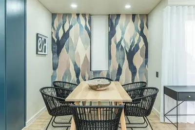 a dining room with chairs and a wooden table at Modern Central 1 BR Apartment in Stellenbosch