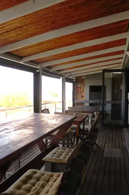 a dining room with wooden tables and chairs at 17 Suikerbossie in Hermanus