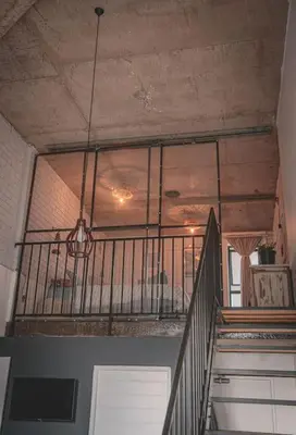 a room with a staircase with a ceiling and a window at Kape Loft in Cape Town