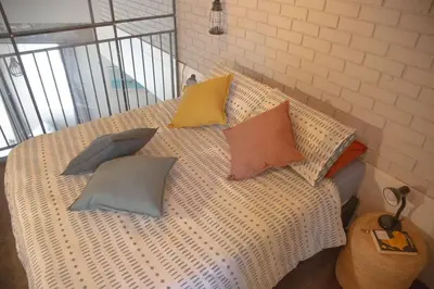 a bed with four pillows on it with at Kape Loft in Cape Town