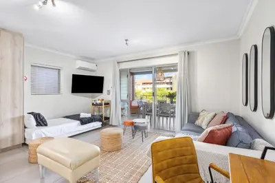 a living room with a couch and a tv at Mayfair 246 by Host Agents in Cape Town
