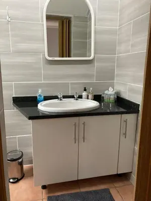 a bathroom with a sink and a mirror at The High Street Accommodation in Durbanville