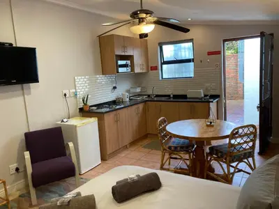 a kitchen and dining room with a table and chairs at The High Street Accommodation in Durbanville