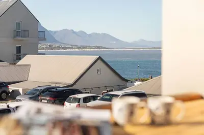a parking lot with cars parked in front of a building at Sea-View Studio - Hermanus Waterfront Apartments in Hermanus
