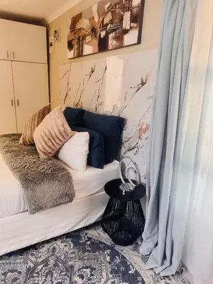 a living room with a couch and curtains and a table at Greens Haven, Your Private escape in Cape Town in Cape Town