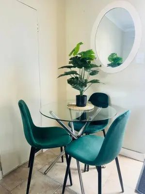 a dining room with a glass table and green chairs at Greens Haven, Your Private escape in Cape Town in Cape Town