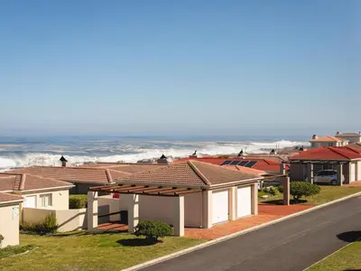 a row of houses with the ocean in the background at Coastal Living in Hermanus
